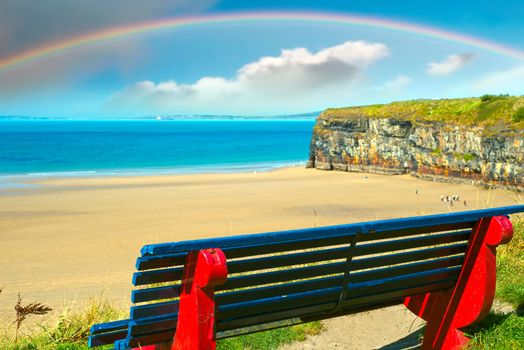 cliff walk bench overlooking the beautiful beach with rainbow in ballybunion