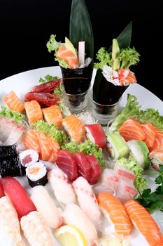 round plate of sashimi and sushi with mixed vegetables and ice