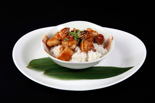 chicken nuggets with rice in white plate on a black background