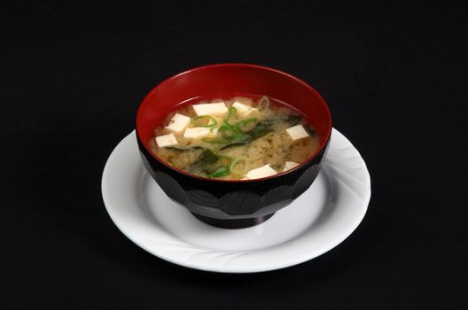 basin with fish soup on a black background