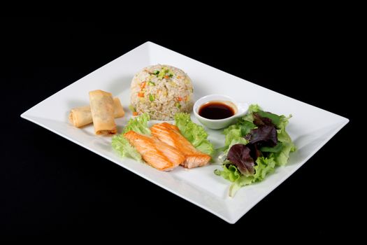 menu of grilled fish with rice and vegetables on white plate, on black backgrpound