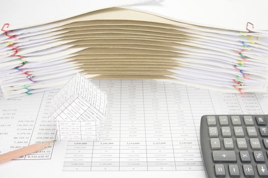 House and pencil with calculator on finance account have brown envelope between overload of old paperwork as background.