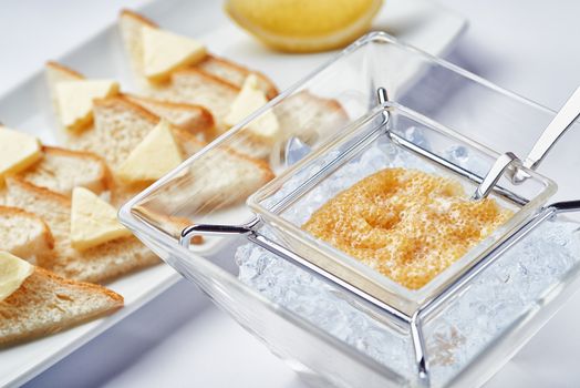Breakfast fresh caviar on ice with toasts