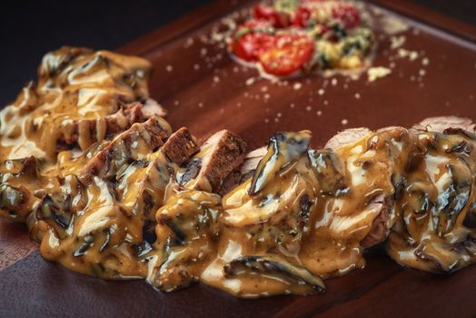 grilled beef with tomato in cream sauce on the board