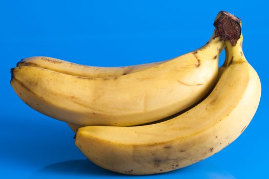small bunch of ripe bananas isolated on light blue background