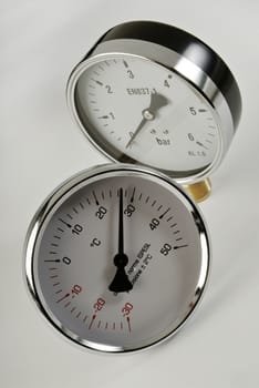 industrial thermometer and barometer on a white background