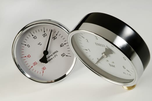 industrial thermometer and barometer on a white background