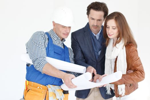 Foreman and a young couple looking at construction plan