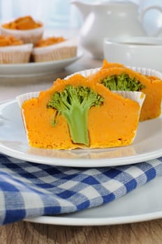 Pumpkin muffin with broccoli in a cut on a plate