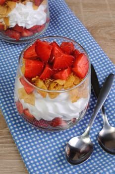 Dessert of strawberries with whipped cream and corn flakes