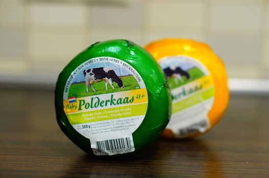 POZNAN, POLAND - AUGUST 25, 2015: Dutch polderkaas cheese with herbs in plastic foil