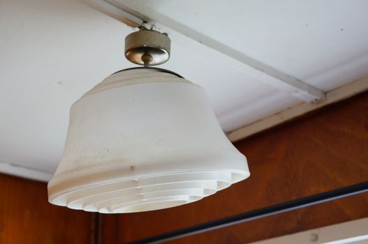 White plastic electric lamp hanging on ceiling 