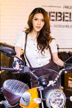 BANGKOK - AUGUST 1 : Unidentified model with Ducati Scrambler motorcycle on display at Bangkok International Grand Motor Sale 2015 (Big Motor Sale 2015) is exhibition of vehicles for sale on August 1, 2015 in Bangkok, Thailand.