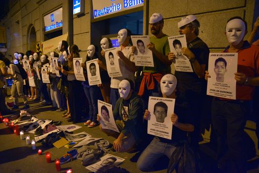 SPAIN, Madrid: Protesters wearing white masks rally outside the Embassy of Mexico in Madrid, Spain on September 25, 2015, while holding up signs displaying photographs of missing Mexican students who disappeared in Iguala, Mexico on September 26 last year. Forty-six students who attended Ayotzinapa Rural Teachers' College went missing with the circumstances surrounding their disappearance still unclear