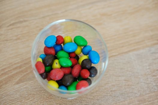 Colorful chocolate peanuts in glass
