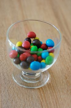 Colorful chocolate peanuts in glass