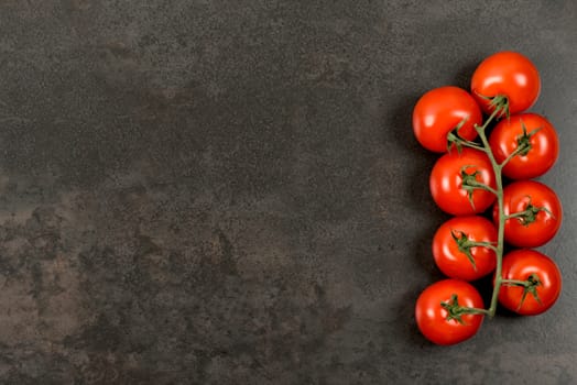 Tomatoes on dark table with copy space