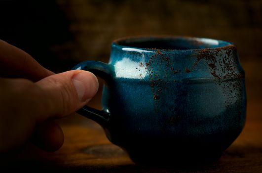 Coffee in grunge blue clay cup on rustic wooden background