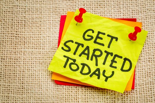 Get started today reminder - handwriting on a sticky note against burlap canvas
