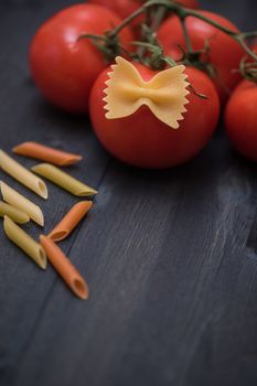 food background on rustic wood with pasta and tomatoes