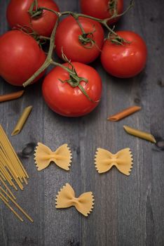 food background on rustic wood with pasta and tomatoes