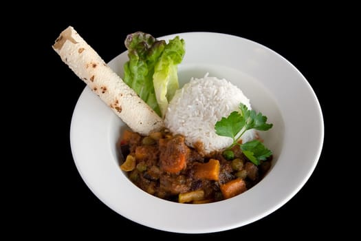 A bowl of Indian vegetable curry with rice and naan