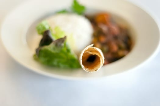 A bowl of Indian vegetable curry with rice and naan