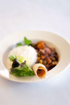 A bowl of Indian vegetable curry with rice and naan