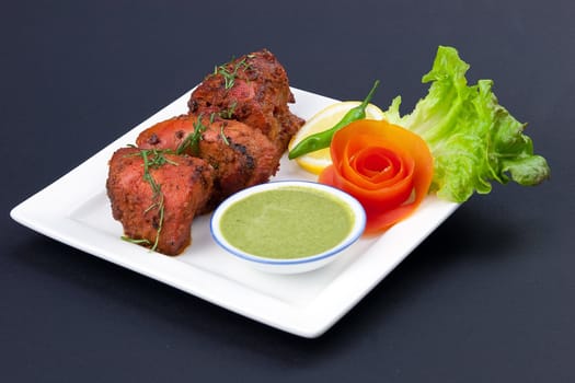 Delicious Indian tandoori chicken with salad garnishings
