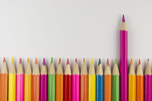 Abstract composition of a set wooden colour pencils against a white background
