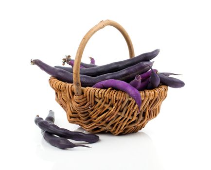 Red bean pods in wicker basket over white background