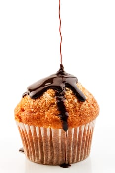 Homemade muffin with liquid chocolate on white background.Vertical image