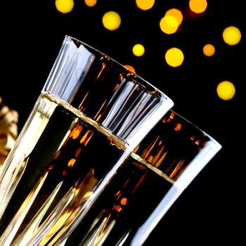 Champagne glasseson dark background with bokeh lights