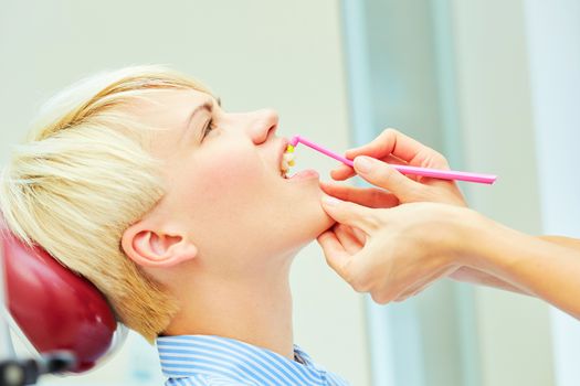 dentist brushing teeth to her patient in dental clinic