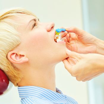 dentist brushing teeth to her patient in dental clinic