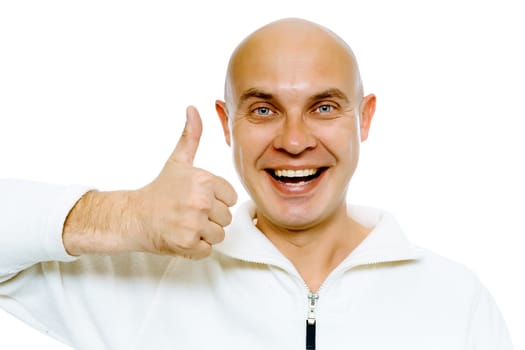 Bald smiling blue-eyed man in a white jacket with thumb up. Studio. isolated