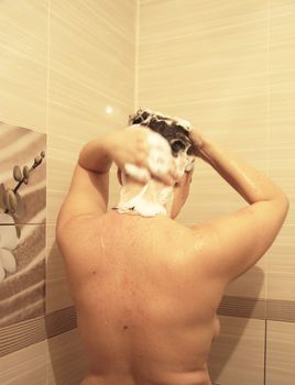 Adult woman washing her hair in the shower