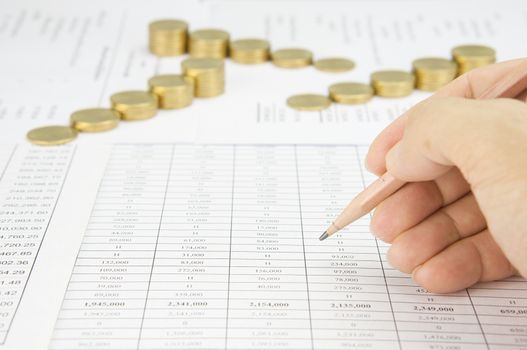 Man holding pencil for audit have blur step of gold coins on finance account as background.