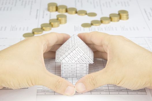 Man protect around house have blur step of gold coins on finance account as background.