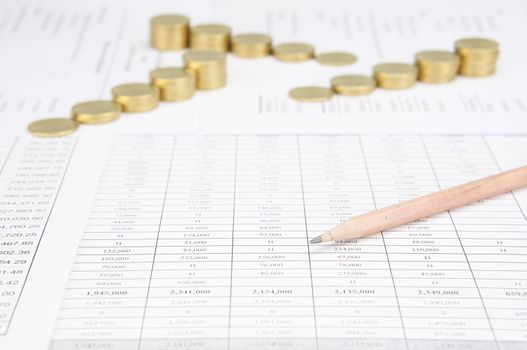 Brown pencil have blur step of gold coins on finance account as background.