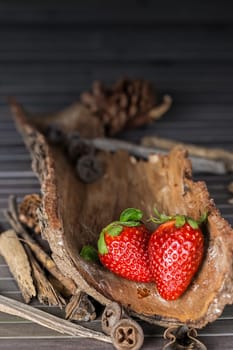 Strawberries with rustic decor in a wooden table. Vertical image.