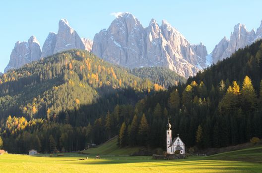 The church of San Giovanni in Ranui (Sankt Johann) in front of the Geisler or Odle dolomites mountain peaks in Santa Maddalena (Sankt Magdalena) in the Val di Funes in Italy.