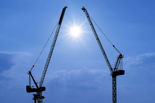 silhouette of construction crane with beautiful sunlight background
