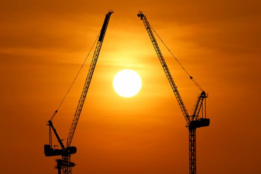 silhouette of construction crane with beautiful sunset background