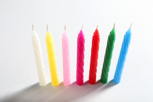 seven birthday colored candles on white background