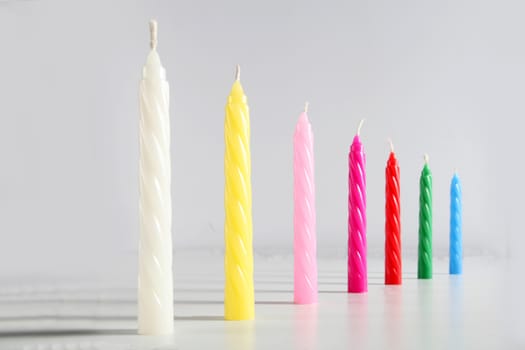 seven birthday colored candles on white background