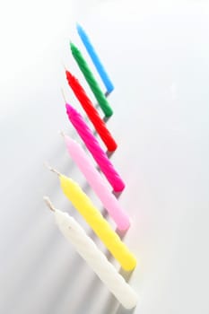 seven birthday colored candles on white background