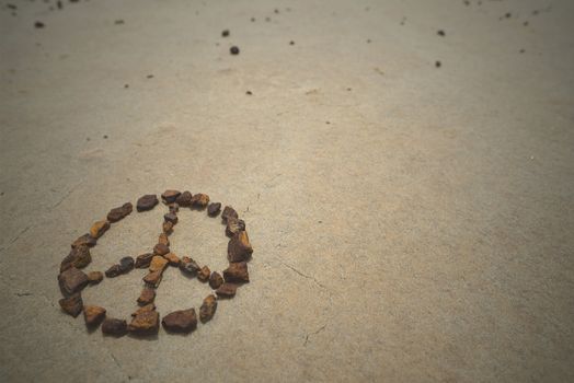 Peace symbol made with rocks on beach sand. Summer hipster background.