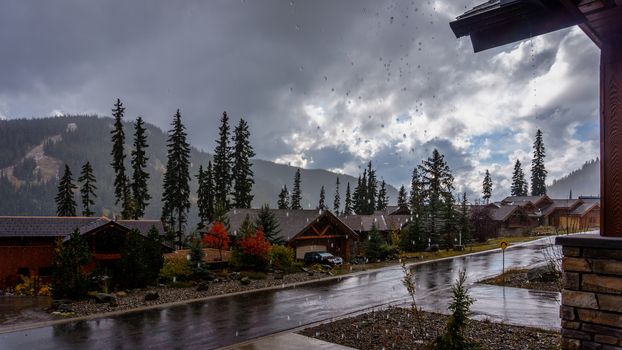 Raindrops falling from the Roof on a dark, cloudy, wet and rainy day in the mountain village of Sun Peaks on a cold autumn day