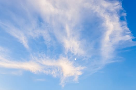 blue sky and the moon background with tiny clouds .